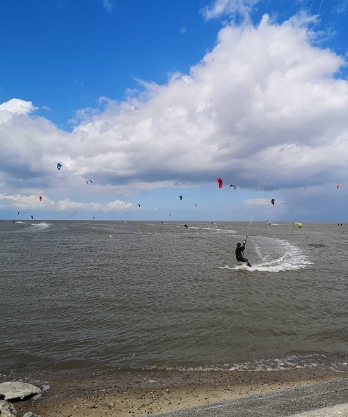 Kyte-Surfer am Strand der Nordsee im Urlaub im Ferienhaus mit Hund